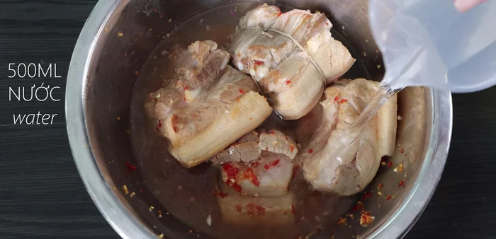Arrange the marinated pork belly and peeled duck eggs in the rice cooker.