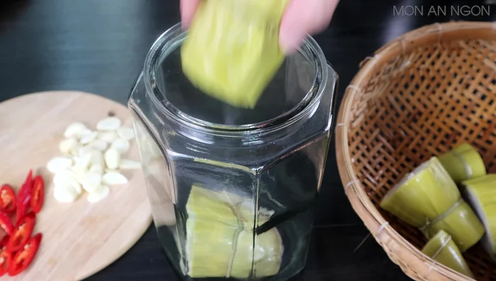 Layer banana stems, garlic, and chili pepper in a clean, dry glass jar.
