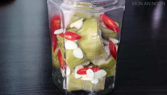 Pour the cooled vinegar and sugar water over the banana stems, ensuring they are fully submerged.