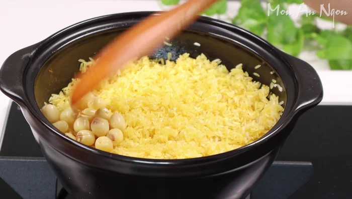 Add the boiled lotus seeds and lotus seed water. Cover and cook.