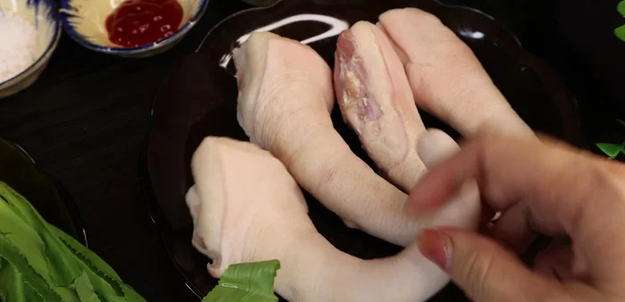 Wash pig's tails with salt, ginger, and wine to remove fishy smell. Scrape the skin clean with a knife.