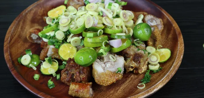Combine the fried pig's tails with the prepared sauce, garlic, shallots, lemongrass, coriander, and ground pepper. Mix well.