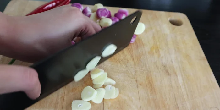 Prepare onion, garlic, and chili by slicing them thinly.