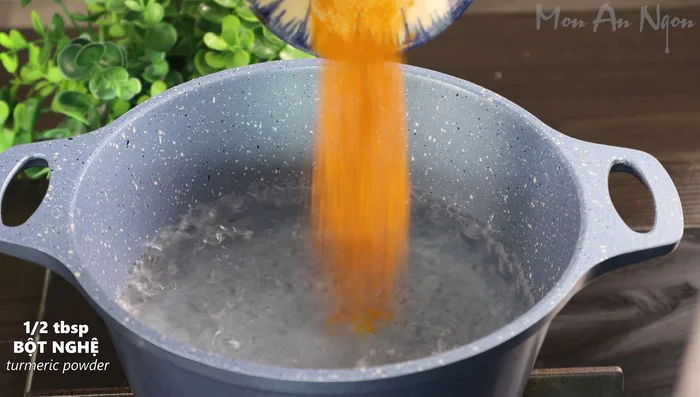 Boil half a pot of water with half a tablespoon of turmeric powder and half a tablespoon of crushed ginger until it boils. Add the chicken wings and boil for 5 minutes to achieve a beautiful yellow color and fragrant aroma.