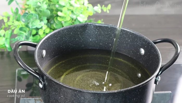 Fry the chicken wings in a pot of hot oil over medium heat, ensuring the oil covers the chicken wings for a crispy texture. Fry until the bottom layer turns golden brown, then flip and continue frying.