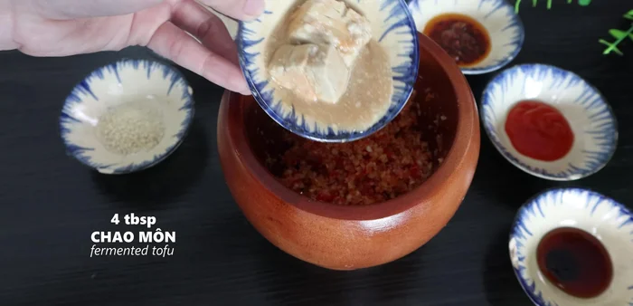 Mix the pounded aromatics with 4 tablespoons of chao mon, 1/2 tablespoon of seasoning powder, 1/2 tablespoon of sugar, 1/4 tablespoon of five-spice powder, 1 tablespoon of satay, 1/2 tablespoon of chili sauce, and 1/2 tablespoon of oyster sauce.