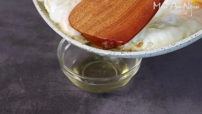 Pour the sauce over the fried eggs. Add green onions and chili for garnish.