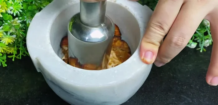 Shred the chicken: Shred the cooked chicken using a mortar and pestle.
