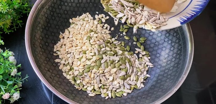 Toast seeds and nuts: Stir-fry the larger seeds until golden and crispy. Add smaller seeds and nuts later to prevent burning. Add the shredded chicken, jackfruit, ginger, lotus seeds, and pumpkin seeds and stir well.