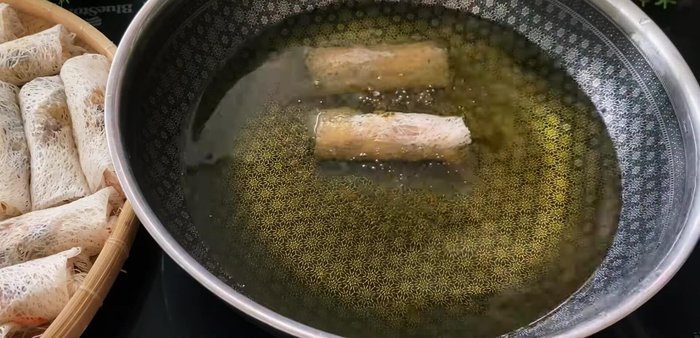 Heat oil in a frying pan. Fry spring rolls until golden brown and crispy, using a double-frying method for extra crispness.