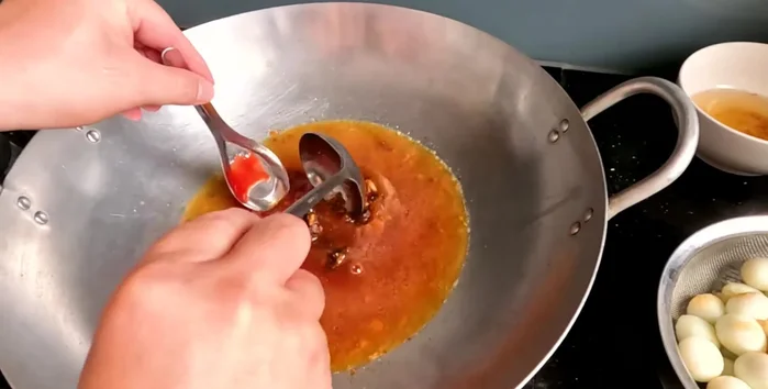 Mash the tamarind and simmer the sauce until it thickens.
