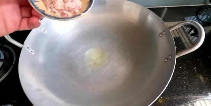 In a separate pan, heat some oil and sauté minced garlic until fragrant.