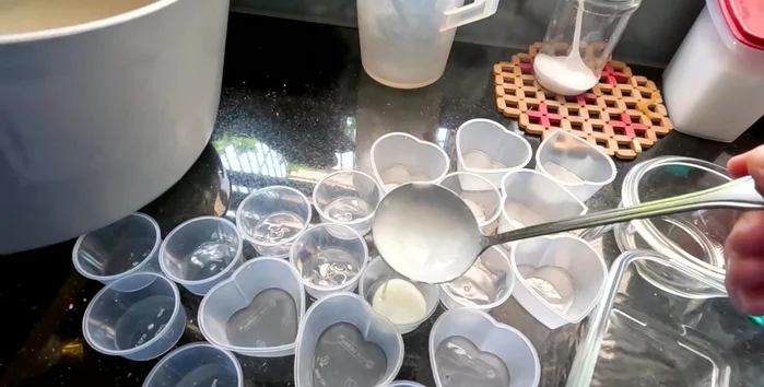 Layer the jelly in a mold: start with a layer of the colored jelly, add fruit pieces, then add a layer of the white milk jelly. Repeat until the mold is full. Allow each layer to set slightly (3-4 minutes) before adding the next.