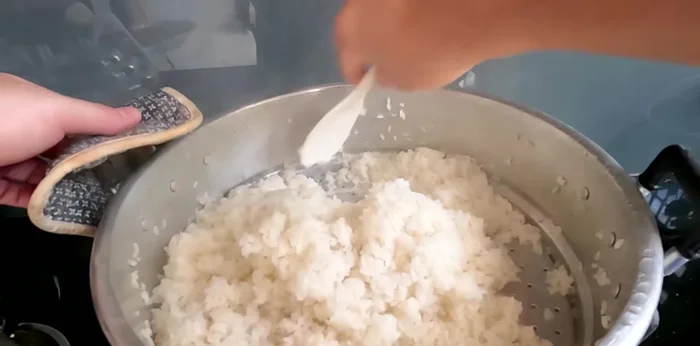 Spread the cooked sticky rice on a tray to cool quickly and evenly (about 1-2 cm thick). (283.36)