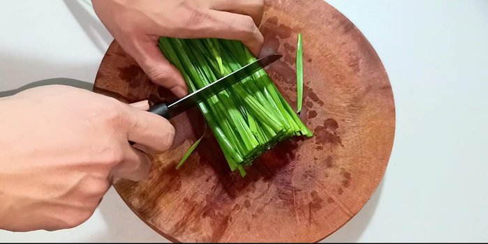 Prepare ingredients: wash and chop leaves (5-6cm), cut garlic into small pieces for blending, chop chili peppers and turmeric into small pieces for blending. [45.16, 69.68, 98.079]