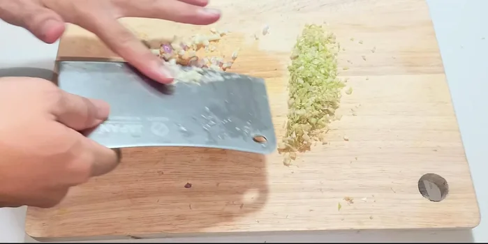 Combine the chopped ingredients with the pre-cooked pork in a bowl.