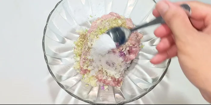 Add sugar, MSG, fish sauce, sesame oil, oyster sauce, and ground pepper to the pork mixture.