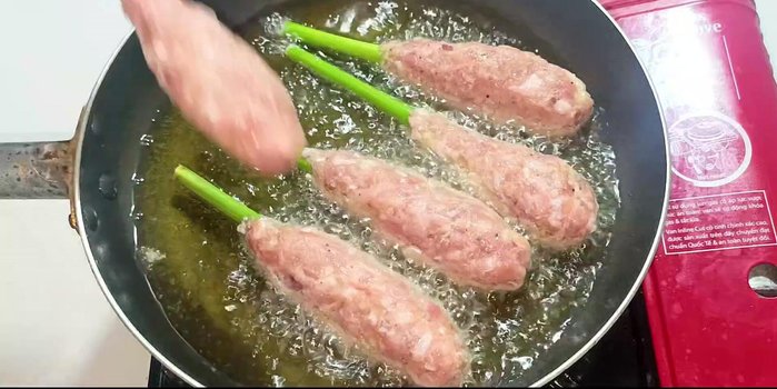 Fry the lemongrass-wrapped pork for 2-3 minutes per side, or until golden brown and crispy.