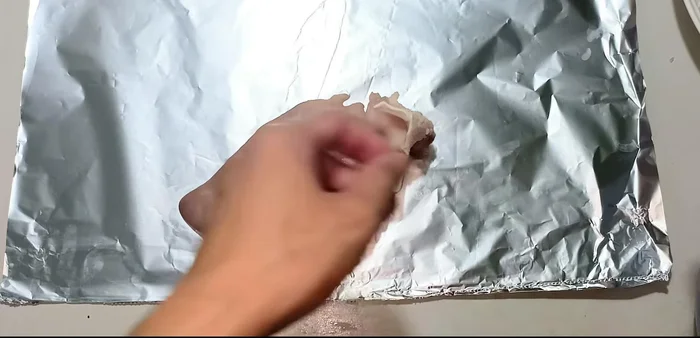 Roll the marinated tongue strips into the pig's hands, pressing firmly to ensure it adheres well. Wrap tightly with aluminum foil and secure with nylon string.