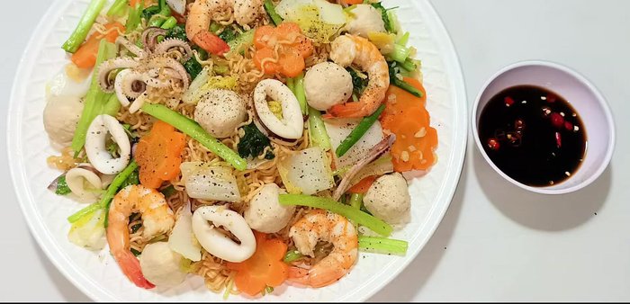 Serve on a plate, garnish with ground pepper, and enjoy with chili sauce.