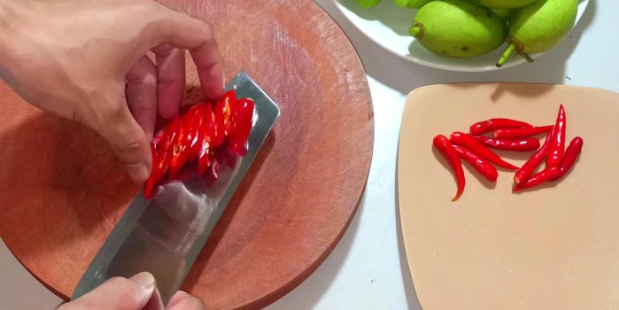 Prepare chilies: Slice the chilies thinly.