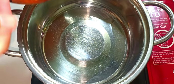 Heat cooking oil in a pot. Saute the remaining pounded shallots, garlic, and chili peppers until fragrant. Add three more whole chili peppers.
