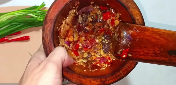 Marinate fish with sugar, MSG, ground pepper, fish sauce, and half of the pounded mixture. Let it marinate for about 15 minutes.