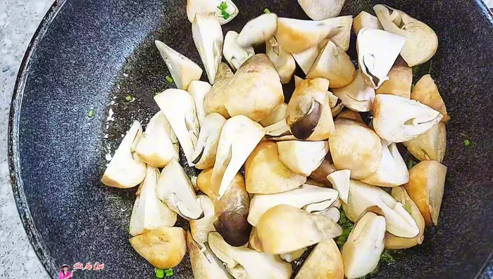 Add straw mushrooms (cut larger ones into bite-sized pieces), stir-fry, and season with sugar, vegetarian seasoning, pepper, and vegetarian fish sauce.