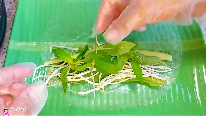 Assemble the spring rolls: Prepare fresh spring rolls with rice paper, vegetables, and spring roll filling.