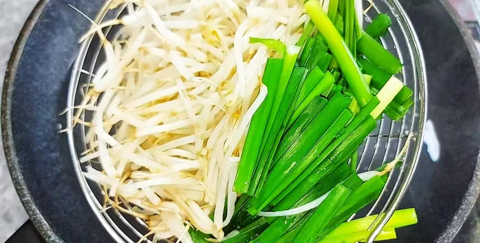 Fry bean sprouts and chives in oil until golden brown.