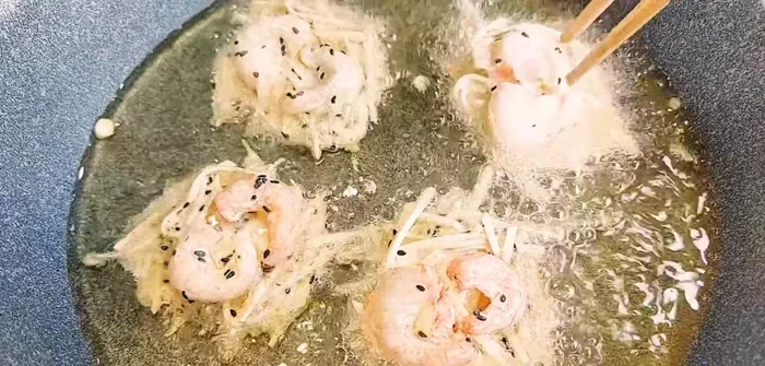 Using a large spoon, scoop the taro mixture into the hot oil and fry until golden brown and crispy. (106.68)