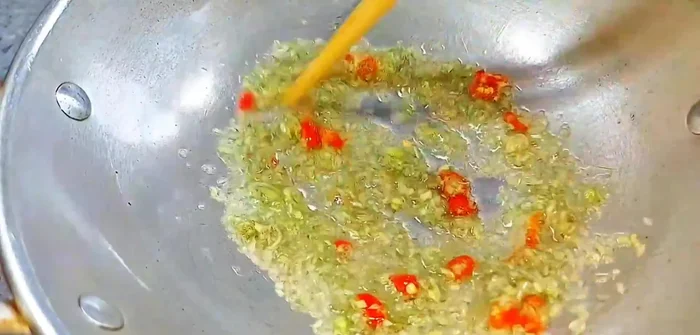Sauté minced lemongrass and chili until fragrant and golden.