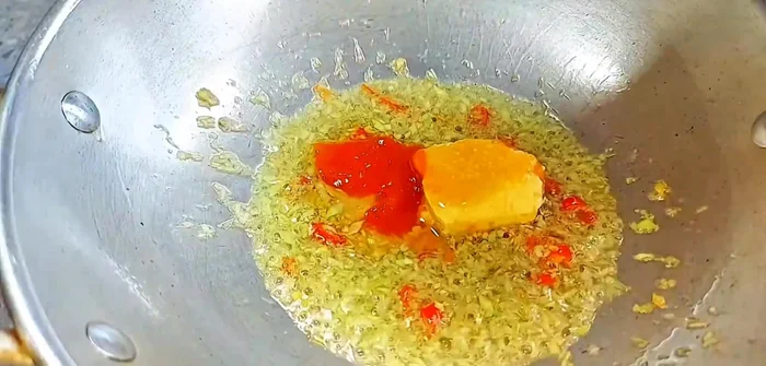 Add chili sauce, chao, sugar, vegetarian seasoning, and five-spice powder.