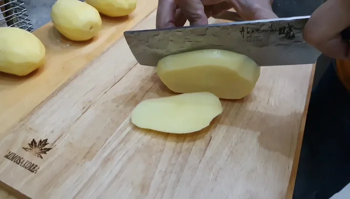 Prepare the potatoes: peel them and slice them into thin pieces for faster cooking.