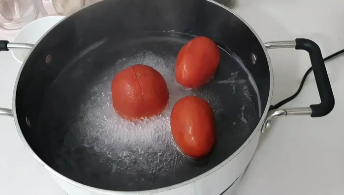 Boil tomatoes until soft. Puree the tomatoes to create a sauce.