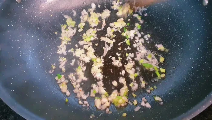 Add blanched mushrooms, carrots, and peas to the pan and stir-fry briefly.