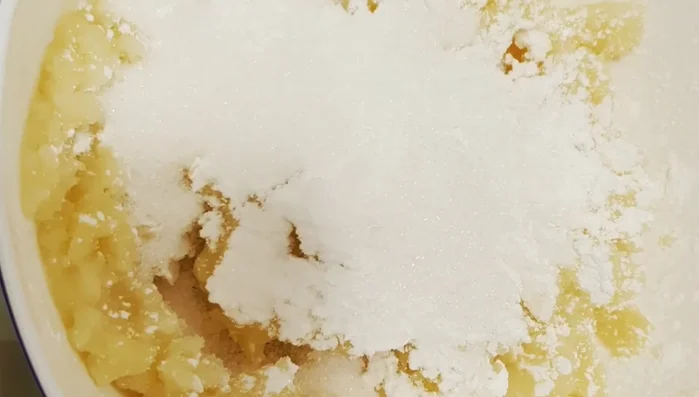 Gradually add 200g of flour and 150g of sugar, mixing until smooth and without lumps.
