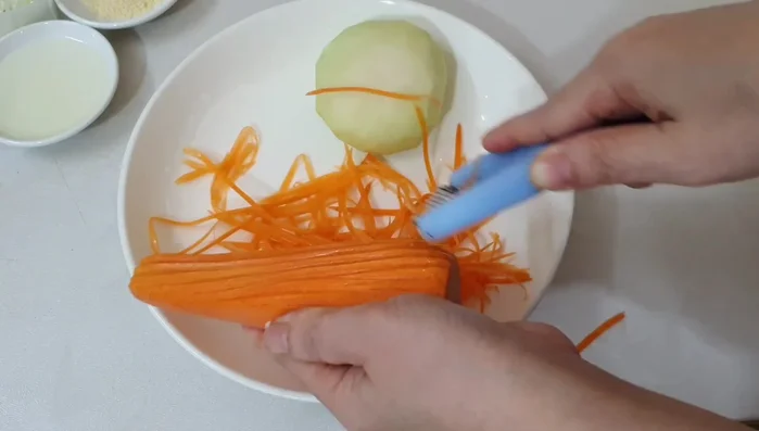 Shred the carrots and kohlrabi.