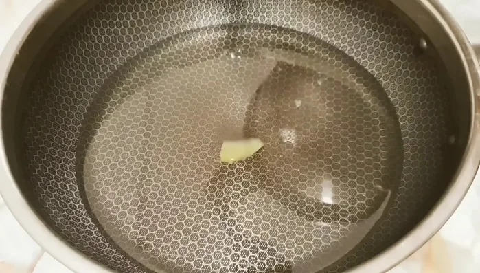 Boil the sugar syrup over high heat to reduce water content. Add ginger, and continue to cook over medium heat, stirring constantly, until the ginger is dry.