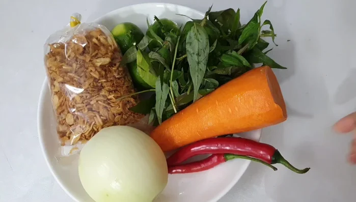 Prepare the carrot, onion, chili peppers, and Vietnamese coriander. Also prepare three lemons and fried dried onions.