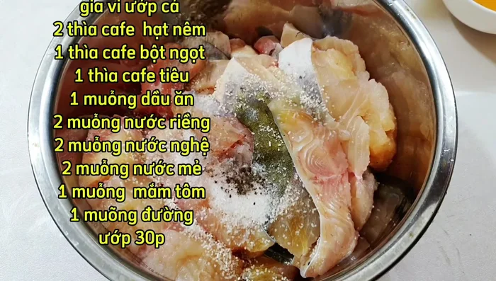 Marinate the catfish with turmeric broth, galangal broth, yeast broth, shrimp paste, pepper, MSG, sugar, and oil for 30 minutes.