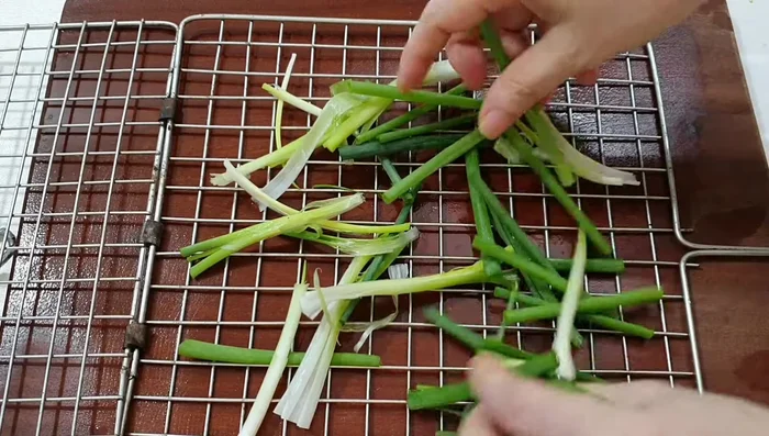 Brush a layer of green onions and dill underneath the grill rack.