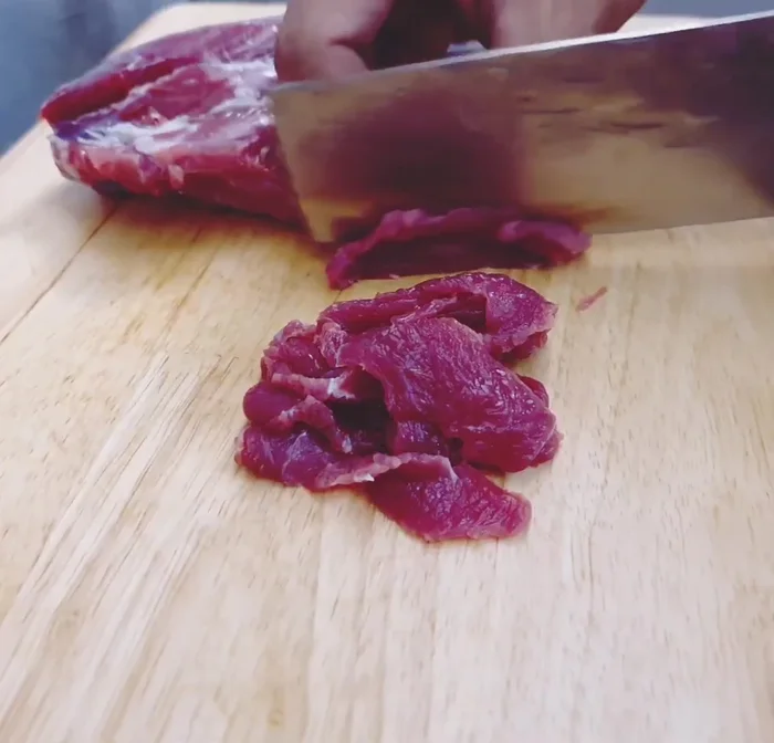 Slice the beef very thinly. This ensures it will be soft and delicious when stir-fried.