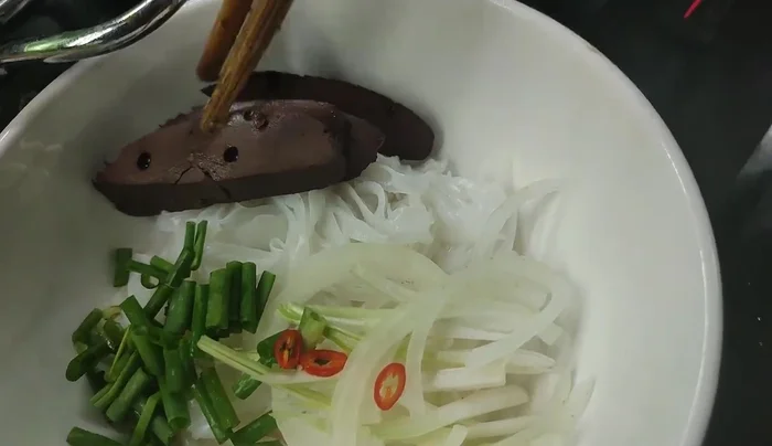Add the cooked chicken, fried dough sticks, and blanched noodles to the bowls.