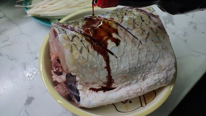 Marinate the grass carp with soy sauce, chili sauce, tomato sauce, salt, pepper, and MSG to remove the fishy smell and create a fragrant aroma. Ensure the fish is evenly marinated.