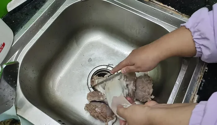 Scrape off the white membrane on the surface and around the throat of the tongue.
