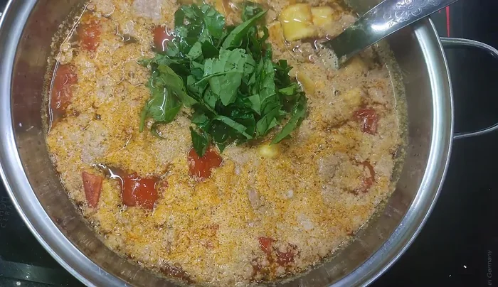 Before serving, add herbs, chopped green onions, and betel leaves.