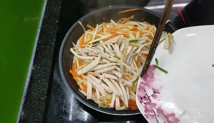 When the vegetables are about 80-90% cooked, add the ham or sausage and stir-fry together.