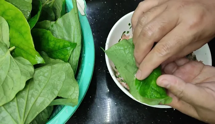 Place a lolot leaf upside down. Add a spoonful of the meat mixture and wrap tightly.