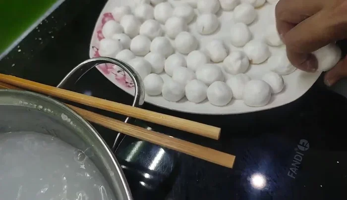 Add the dough pieces to the boiling water. The cake is done when it floats to the surface after sinking three times out of seven.